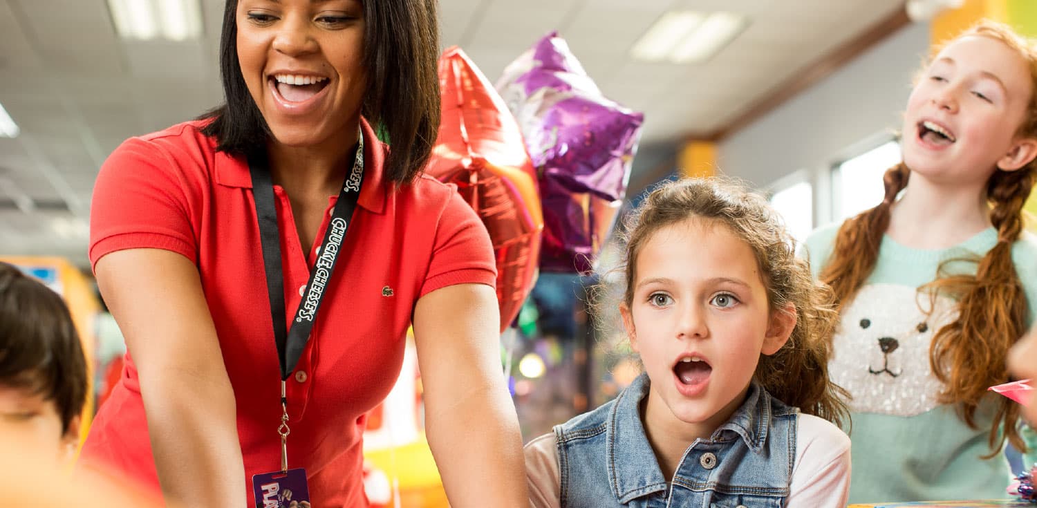 Kids at a birthday party with a Chuck E Cheese female employee